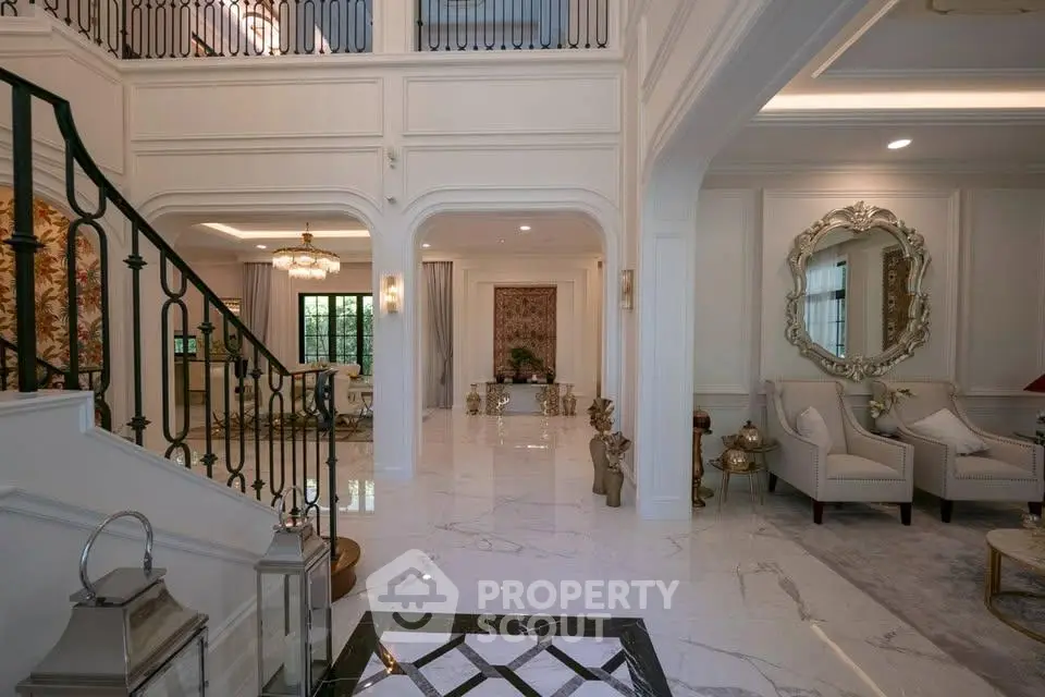 Luxurious living room with elegant staircase and marble flooring in a high-end property.