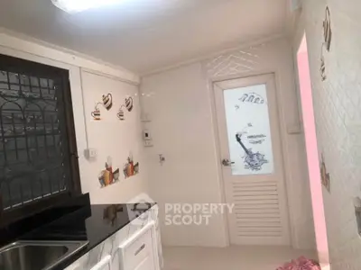 Charming kitchen with modern black countertop and decorative wall tiles, perfect for cozy cooking experiences.