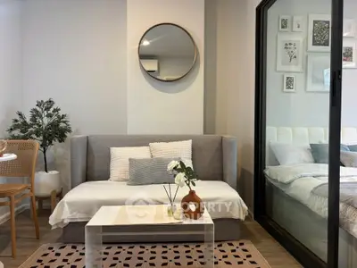 Modern living room with stylish decor and cozy ambiance, featuring a sleek sofa and elegant wall art.