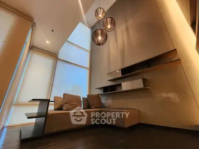 Modern living room with high ceilings and stylish lighting in a luxury apartment.