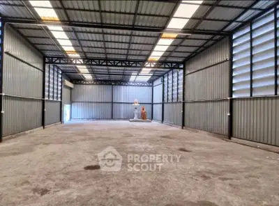 Spacious industrial warehouse with high ceilings and ample natural light, ideal for storage or manufacturing.