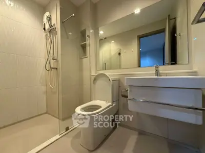 Modern bathroom with glass shower and sleek fixtures in a contemporary apartment.