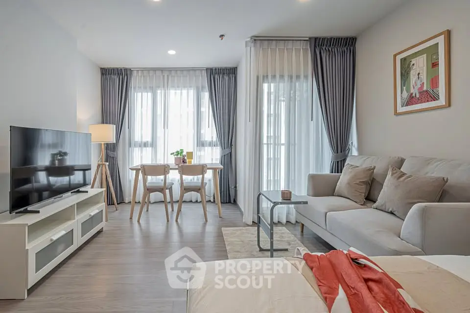Modern living room with stylish decor and natural light, featuring a cozy sofa and dining area.