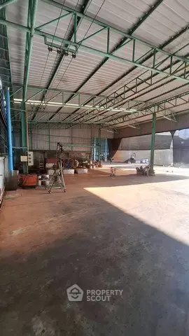 Spacious industrial warehouse with high ceilings and ample natural light.