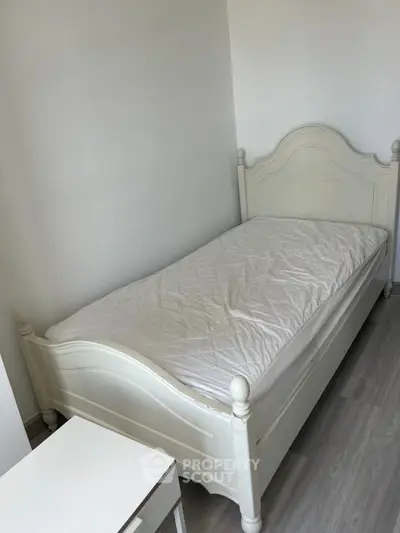 Cozy bedroom with elegant white bed and nightstand, perfect for a serene retreat.