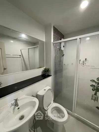 Modern bathroom with sleek fixtures and glass shower enclosure, perfect for a contemporary home.