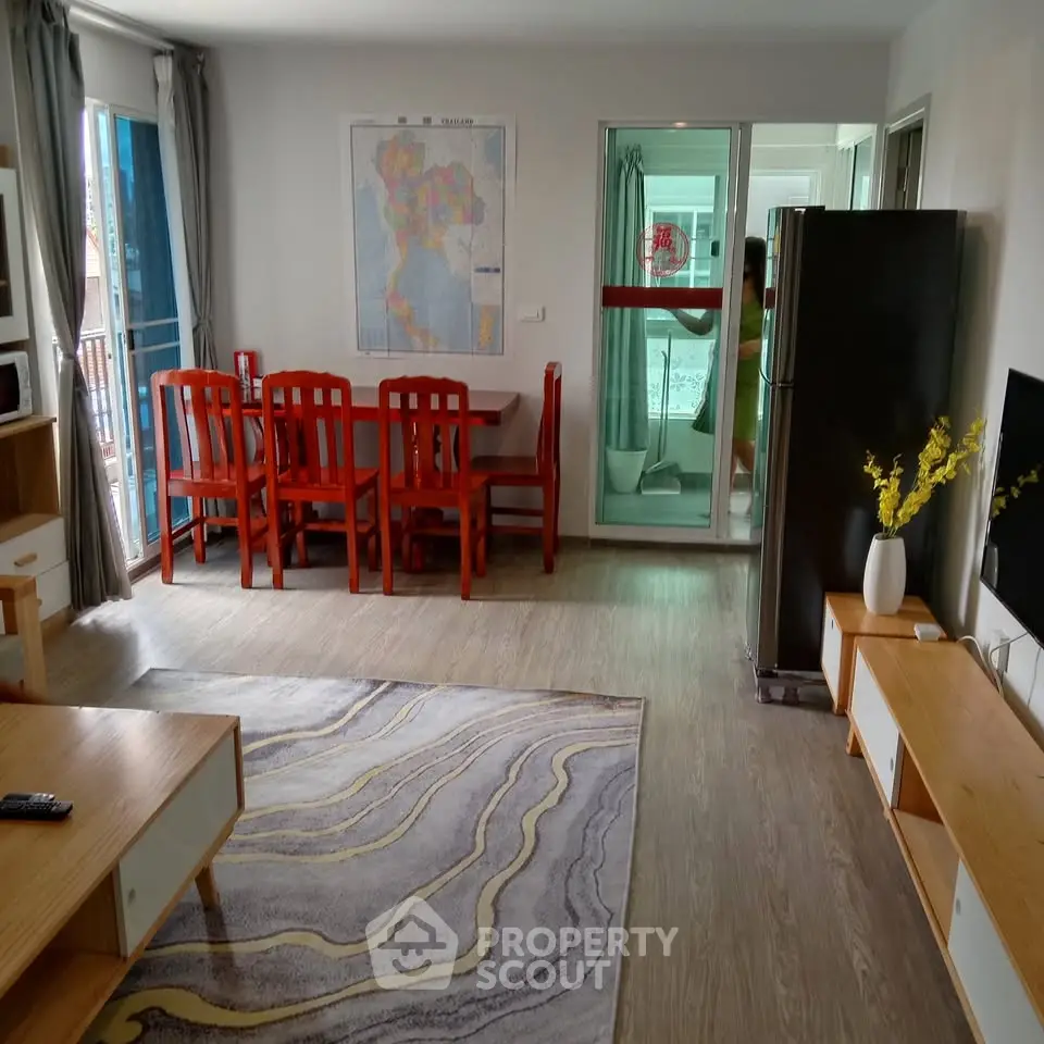 Spacious living room with modern decor and dining area, featuring a large map on the wall and natural light.