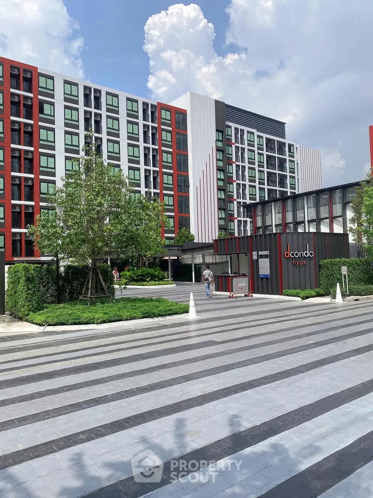 Modern condominium exterior with lush landscaping and contemporary design.