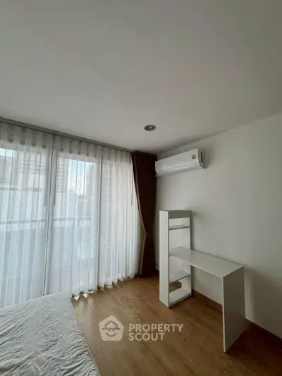 Modern bedroom with large window and minimalist furniture