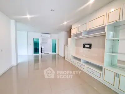 Spacious modern living room with built-in shelving and glossy tile flooring