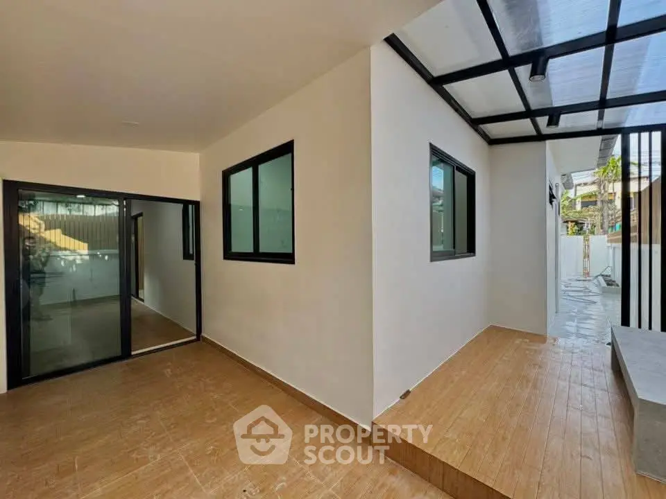 Modern home entrance with sleek glass doors and covered walkway