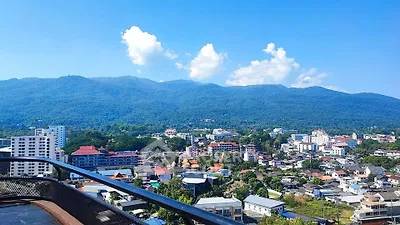 Stunning panoramic city view with mountain backdrop from high-rise balcony.