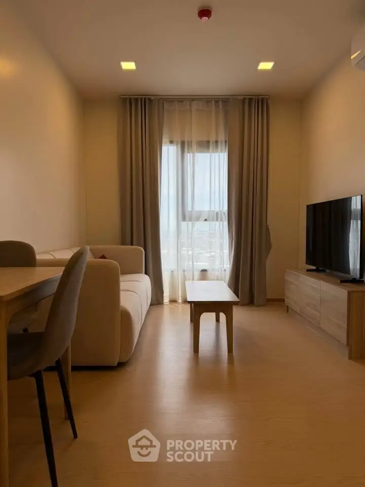 Modern living room with cozy sofa, TV, and dining area in a stylish apartment.