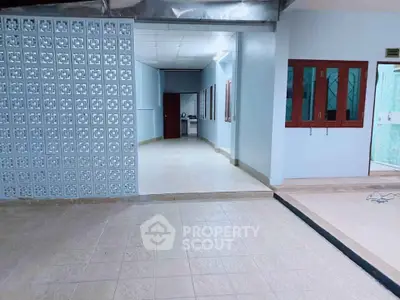 Spacious open-plan interior with tiled flooring and decorative wall partition, ideal for versatile living arrangements.