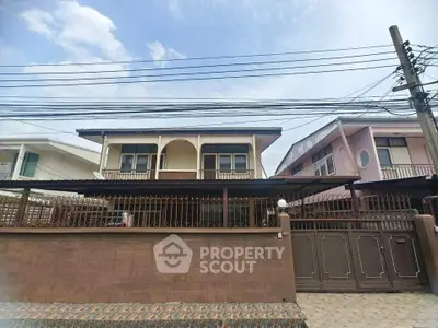 Charming two-story house with gated entrance and spacious balcony, perfect for family living in a serene neighborhood.