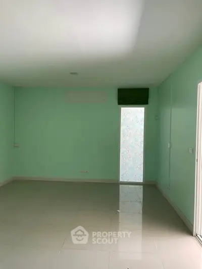 Spacious empty room with mint green walls and tiled floor, perfect for customization.