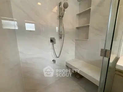 Modern bathroom with sleek marble tiles and built-in shower bench
