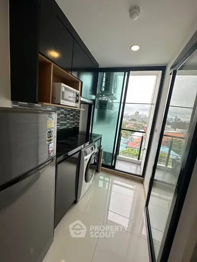 Modern kitchen with sleek appliances and city view from balcony.