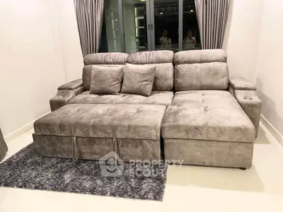 Luxurious modern living room with plush gray sectional sofa and elegant curtains, perfect for relaxation.