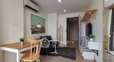 Modern living room with stylish decor and natural light, featuring a cozy sofa and dining area.