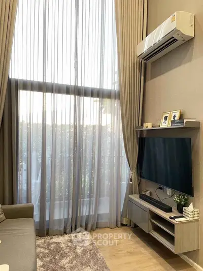 Modern living room with high ceilings, large window, and sleek air conditioning unit.