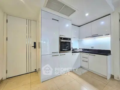 Modern kitchen with sleek white cabinets and built-in oven