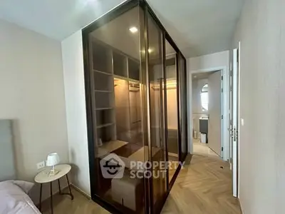 Modern bedroom with glass walk-in closet and elegant wooden flooring