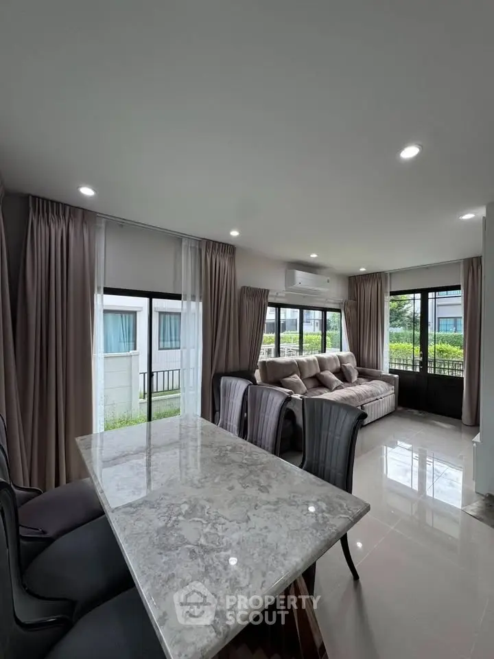 Modern living room with large windows and elegant dining area