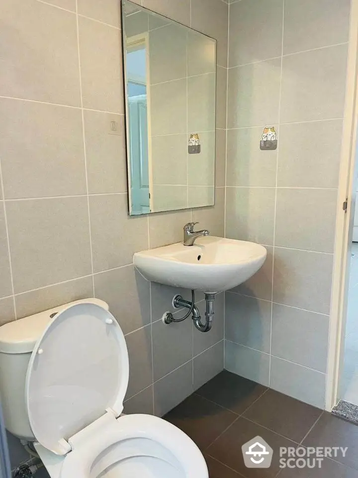 Modern bathroom with sleek sink and toilet in tiled interior