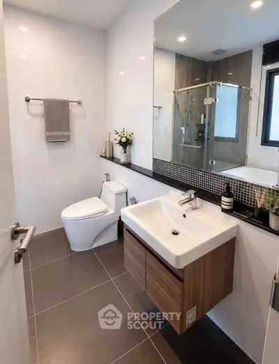 Modern bathroom with sleek fixtures and glass shower enclosure