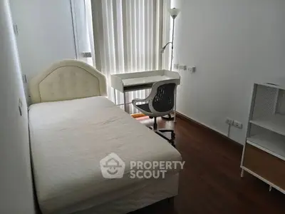 Cozy bedroom with single bed, study desk, and chair, perfect for a minimalist lifestyle.