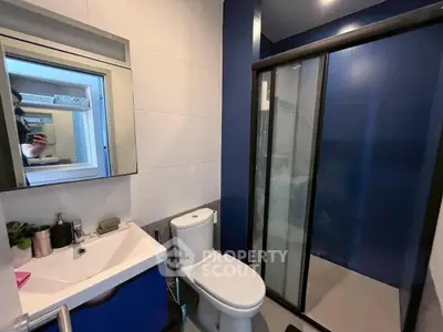 Modern bathroom with sleek shower and stylish vanity in contemporary apartment.