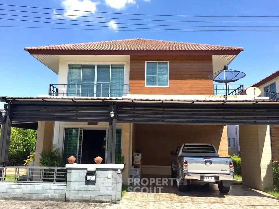 Modern two-story house with carport and satellite dish under clear blue sky.