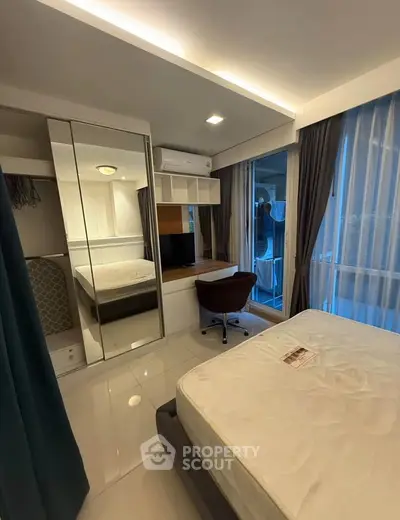 Modern bedroom with mirrored closet and large windows in a stylish apartment.