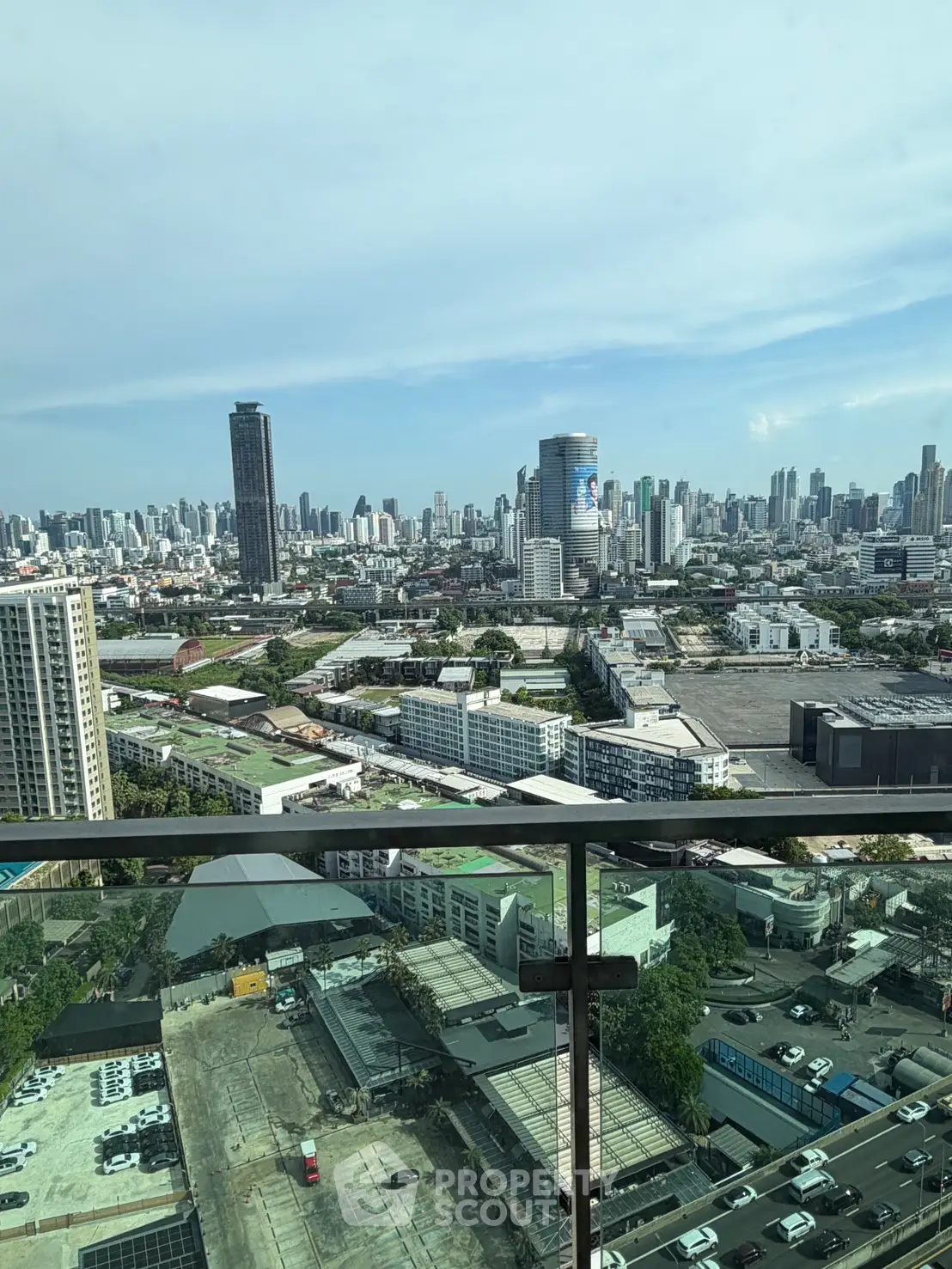 Stunning cityscape view from a high-rise balcony, showcasing urban skyline and modern architecture.