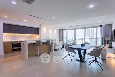 Spacious modern living room with open kitchen and large balcony view