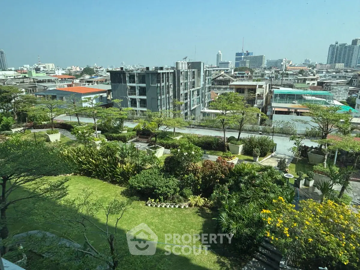 Stunning cityscape view from a lush garden balcony with vibrant greenery and urban skyline.