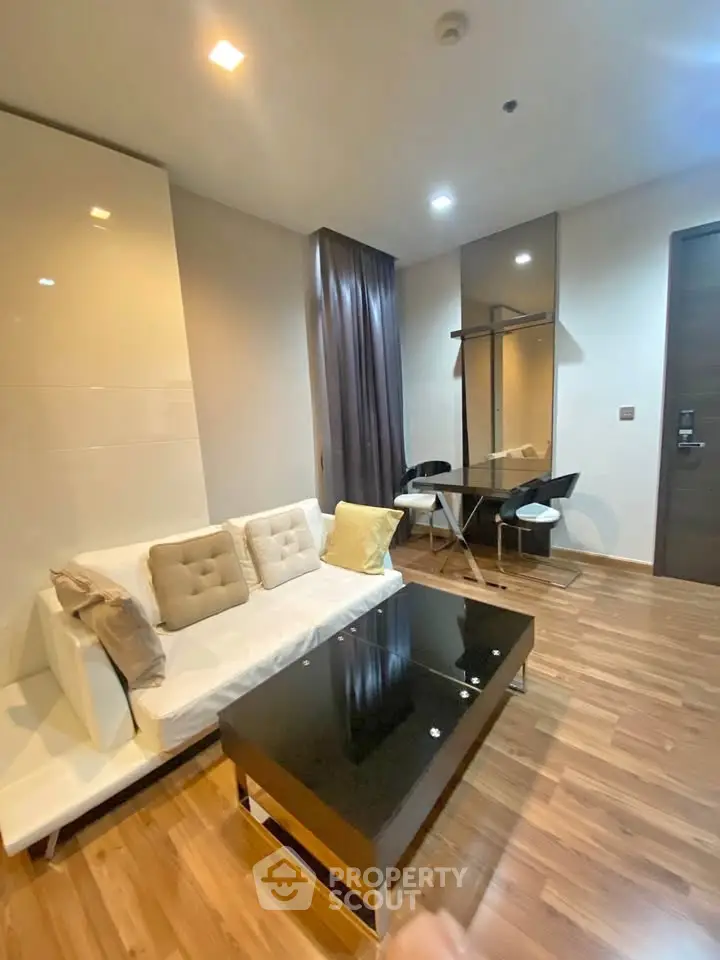 Modern living room with sleek furniture and wooden flooring in a stylish apartment.