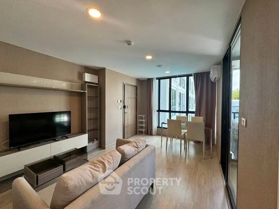 Modern living room with large windows and stylish furniture in a contemporary apartment.