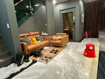 Modern living room with stylish leather sofas and marble flooring, featuring playful decor and cozy ambiance.