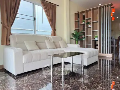 Spacious modern living room with elegant marble flooring and cozy beige sofa.
