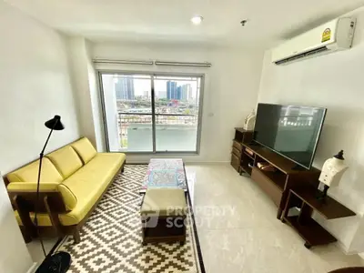 Modern living room with city view, featuring yellow sofa and flat-screen TV.