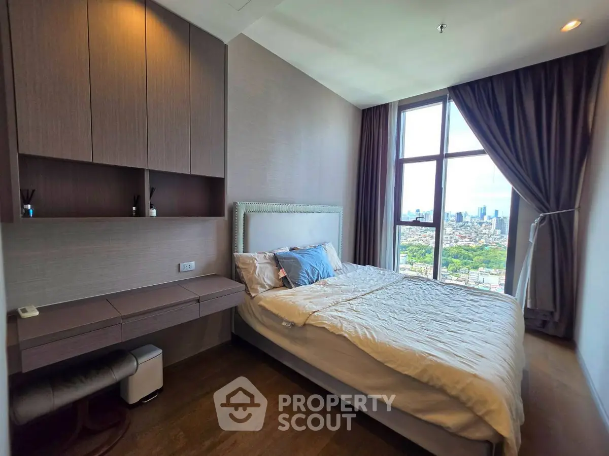 Modern bedroom with city view, featuring stylish decor and large window for natural light.