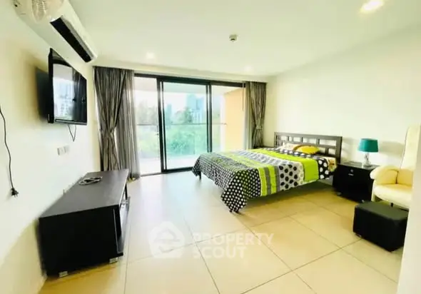 Spacious bedroom with large windows and modern decor in a bright apartment.