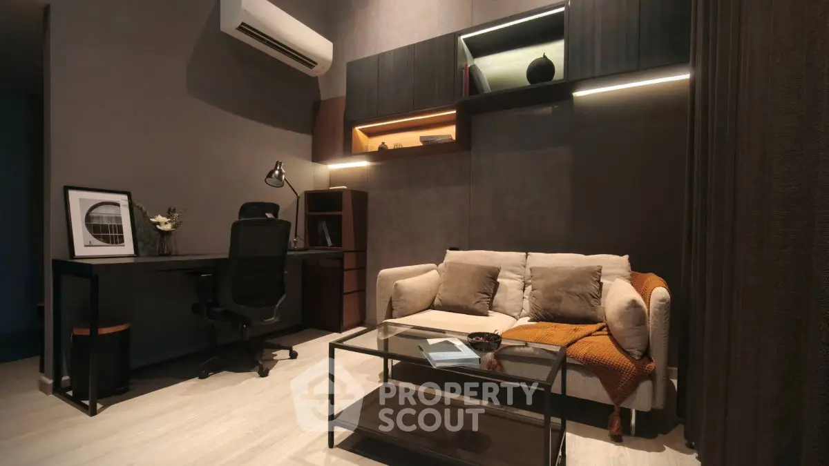 Modern study room with stylish sofa and desk, featuring ambient lighting and contemporary decor.