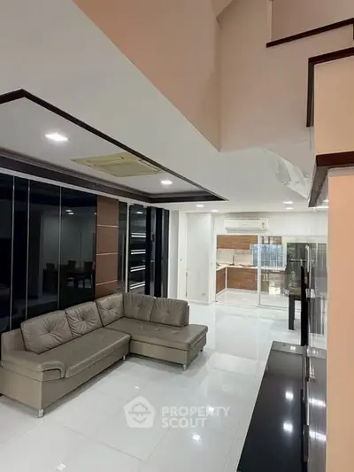 Spacious modern living room with sleek design and open kitchen layout, perfect for contemporary living.