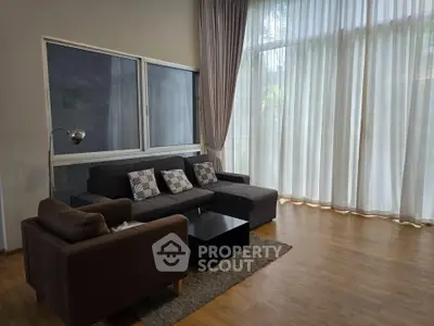 Spacious living room with floor-to-ceiling windows and modern furniture