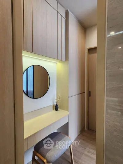 Modern study nook with wooden cabinetry and round mirror in stylish apartment.