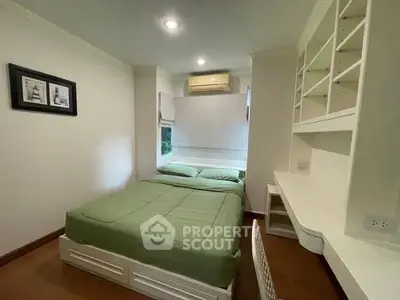 Cozy bedroom with built-in desk and shelves, featuring a comfortable bed and air conditioning.