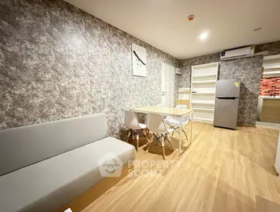Modern living room with stylish decor and open kitchen layout, featuring sleek furniture and wooden flooring.
